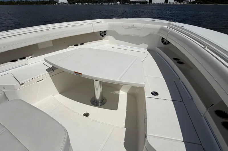 Slide: The Image of 2023 Regulator 37 boat interior with seating and table on calm water. - 23
