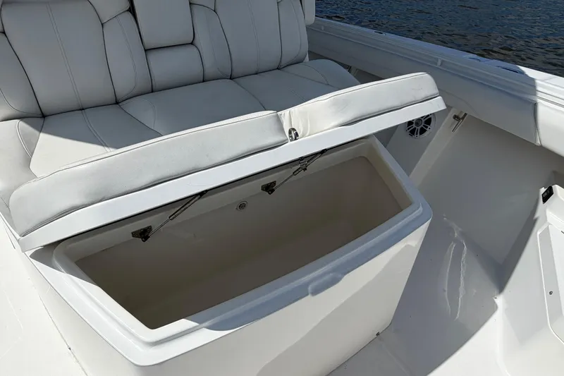Slide: The Image of 2023 Regulator 37 boat with open storage compartment under cushioned seating. - 26