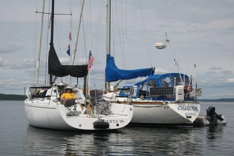 Slide: The Image of Two sailboats anchored on calm water, featuring a Bravura B35 from 1999. - 3