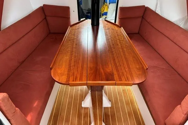 Slide: The Image of Interior of 1999 Bravura B35 sailboat with wooden table and red cushioned seating. - 5