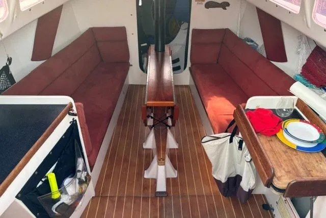 Slide: The Image of Interior of a 1999 Bravura B35 sailboat with red seating and wooden flooring. - 6