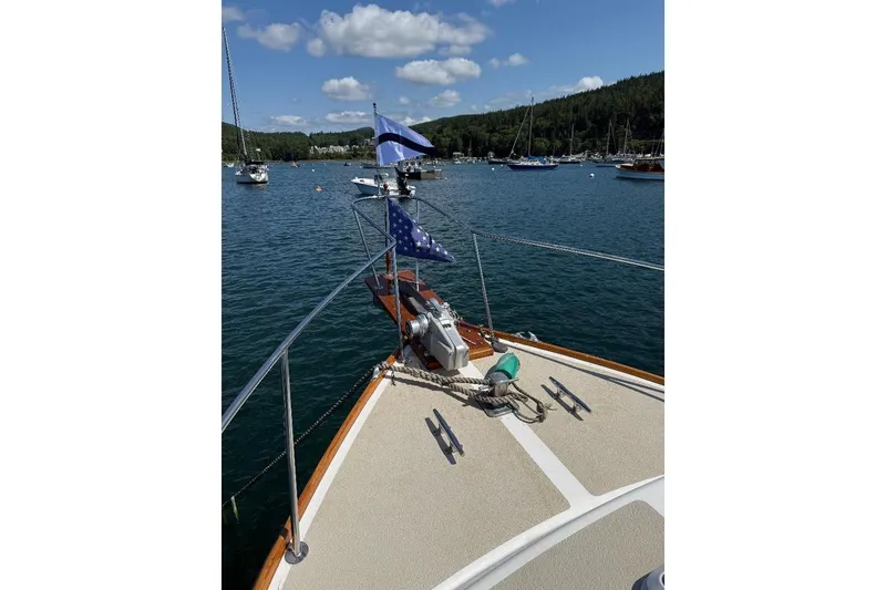 Slide: The Image of Bow view of 1995 Wilbur Weekender boat on a serene lake with sailboats. - 12