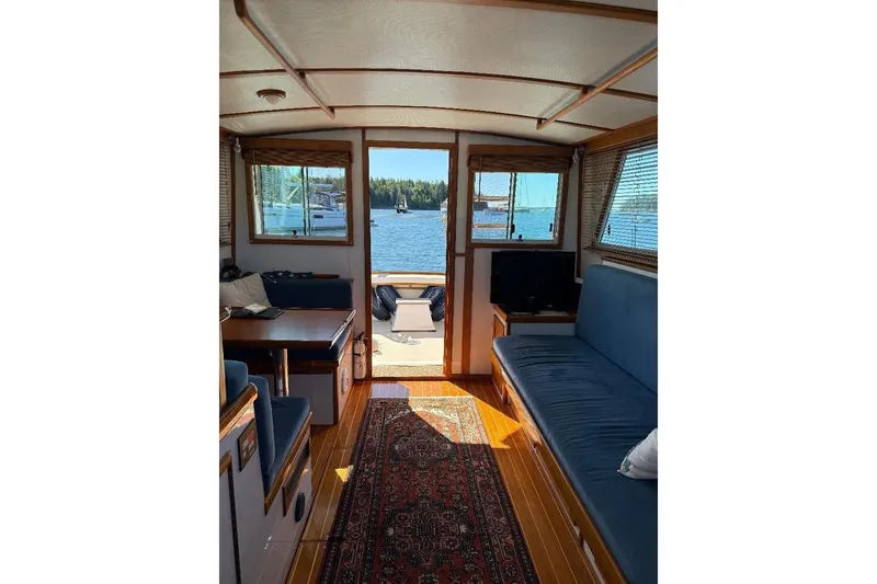 Slide: The Image of Interior of 1995 Wilbur Weekender boat with cozy seating and scenic water view. - 14