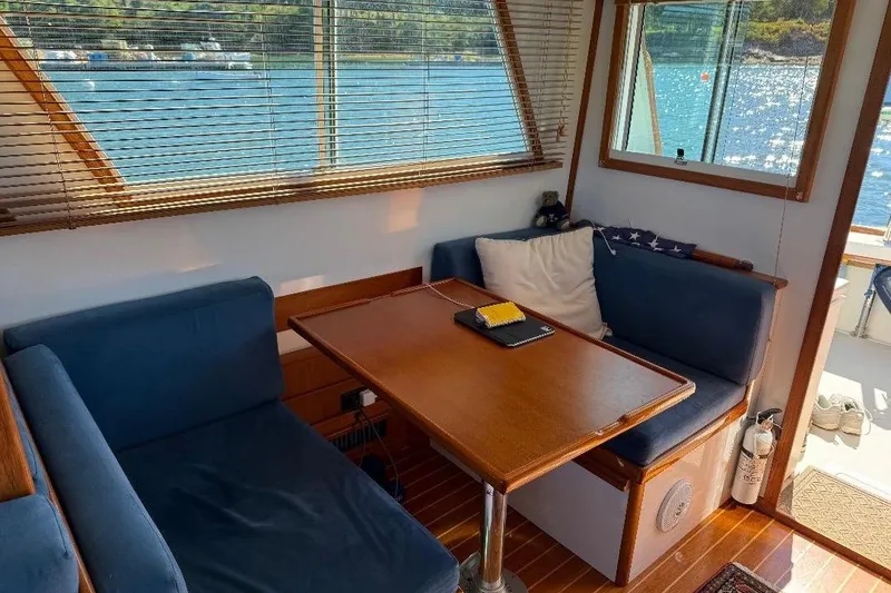 Slide: The Image of Cozy interior of a 1995 Wilbur Weekender boat with blue seating and wooden table. - 15