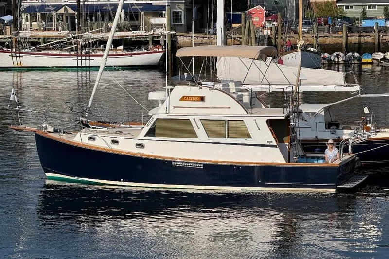 Slide: The Image of 1995 Wilbur Weekender boat docked in a marina, featuring classic design and elegant lines. - 2