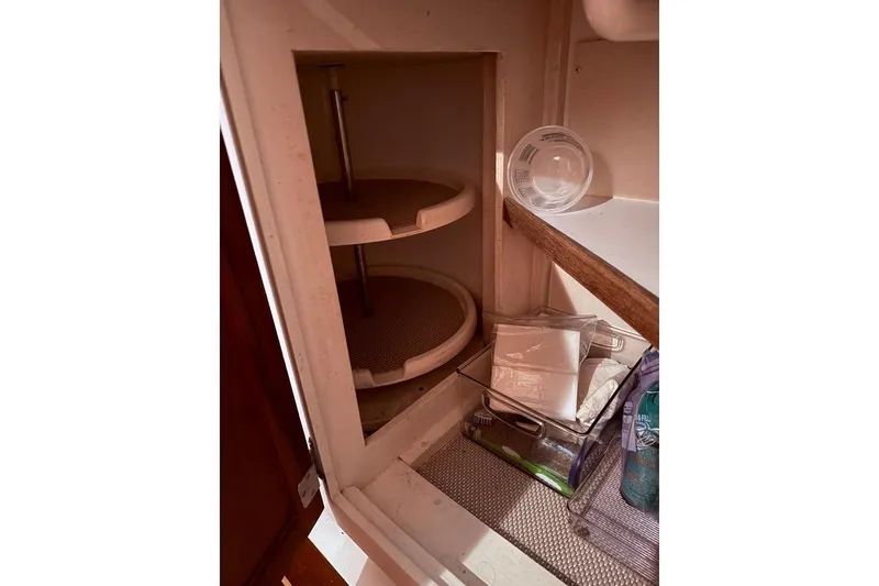 Slide: The Image of Interior storage space in a 1995 Wilbur Weekender boat, featuring shelves and containers. - 23