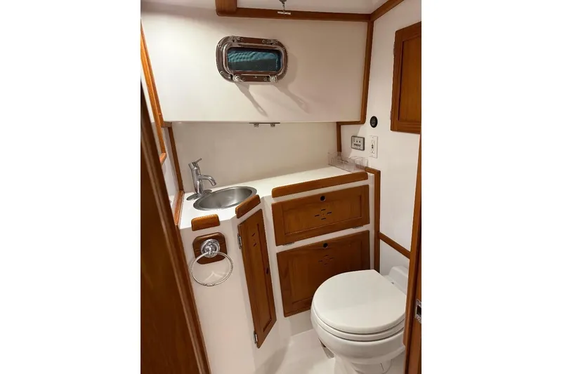Slide: The Image of 1995 Wilbur Weekender boat bathroom with wooden cabinetry and stainless steel sink. - 25