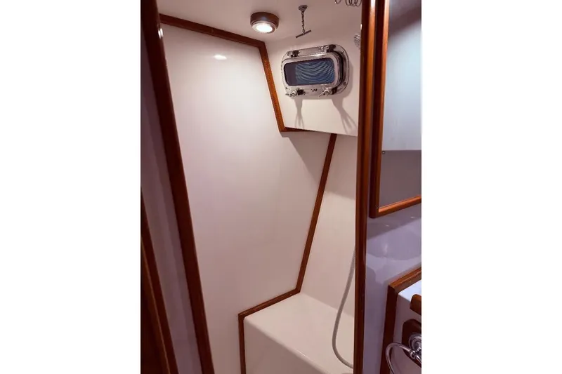 Slide: The Image of Interior of 1995 Wilbur Weekender boat shower with wooden trim and porthole window. - 26