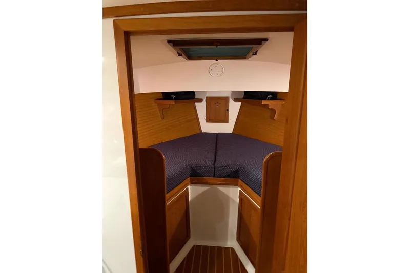 Slide: The Image of Interior cabin of 1995 Wilbur Weekender boat with wooden finish and cozy bedding. - 27