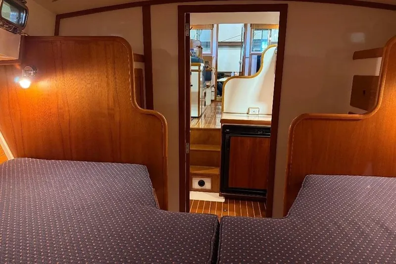 Slide: The Image of Interior of a 1995 Wilbur Weekender boat with cozy wooden cabin and twin beds. - 28