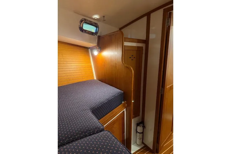 Slide: The Image of Cozy cabin interior of 1995 Wilbur Weekender with wooden paneling and nautical decor. - 30
