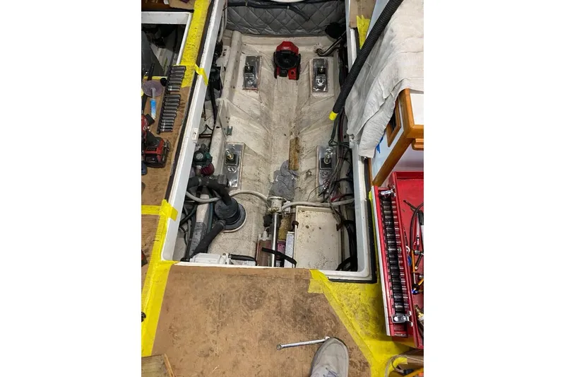 Slide: The Image of Engine compartment of a 1995 Wilbur Weekender boat, showing mechanical components and tools. - 32
