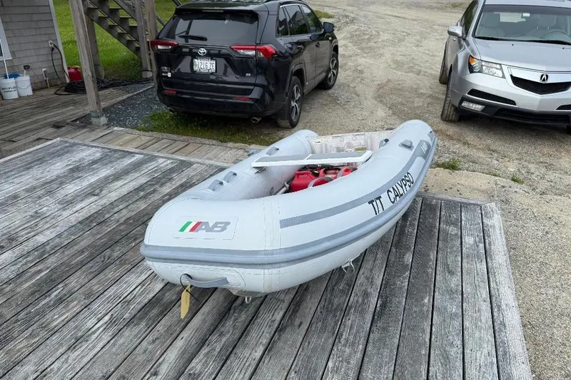 Slide: The Image of Inflatable boat on wooden dock, parked cars in background, Wilbur Weekender 1995. - 35