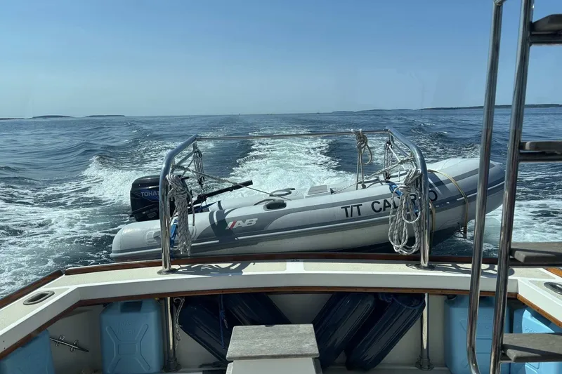 Slide: The Image of 1995 Wilbur Weekender towing an inflatable boat on open water. - 7
