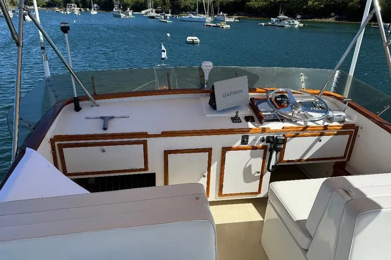 Slide: The Image of 1995 Wilbur Weekender boat helm with Garmin navigation, docked in a scenic harbor. - 9