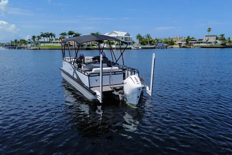 Slide: The Image of 2025 Tahoe Pontoon LTZ 23 on calm water, featuring a sleek design and modern outboard motor. - 1