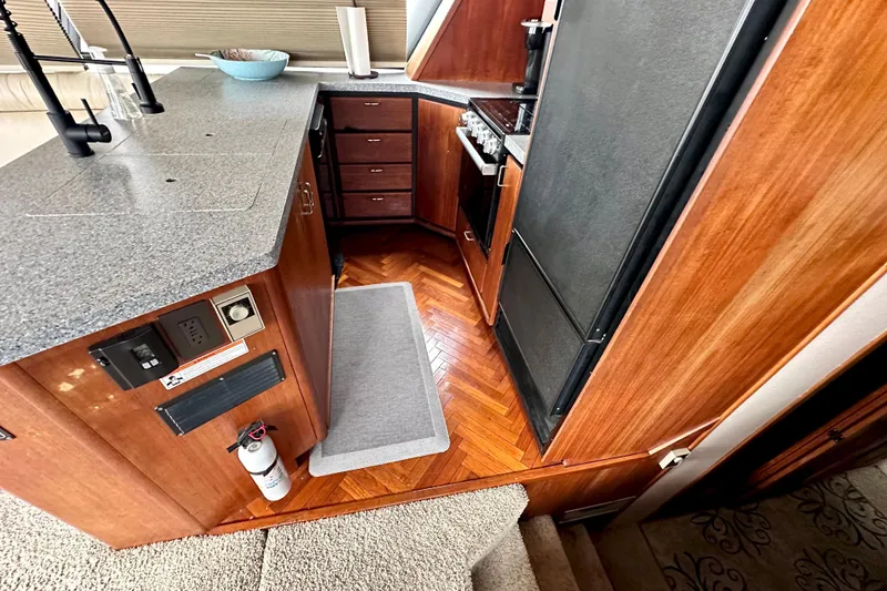 Slide: The Image of Interior of 1993 Bayliner 4588 Pilothouse yacht kitchen with wood cabinetry and modern appliances. - 10