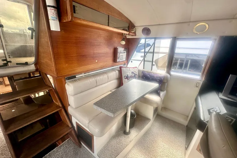 Slide: The Image of Interior of 1993 Bayliner 4588 Pilothouse with cozy dining area and wooden accents. - 11