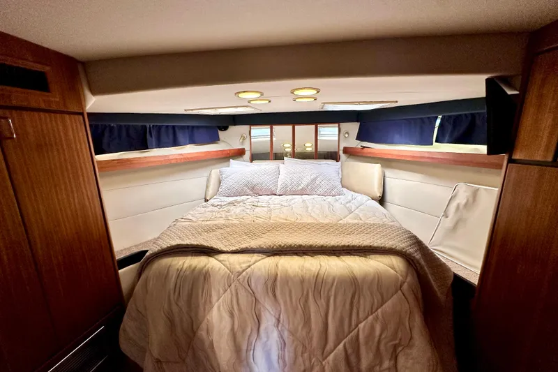 Slide: The Image of Cozy bedroom interior of 1993 Bayliner 4588 Pilothouse yacht with wood accents and soft lighting. - 12