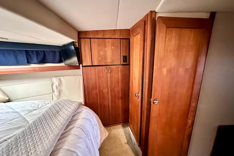 Slide: The Image of Interior cabin of 1993 Bayliner 4588 Pilothouse with wood cabinetry and cozy bedding. - 13