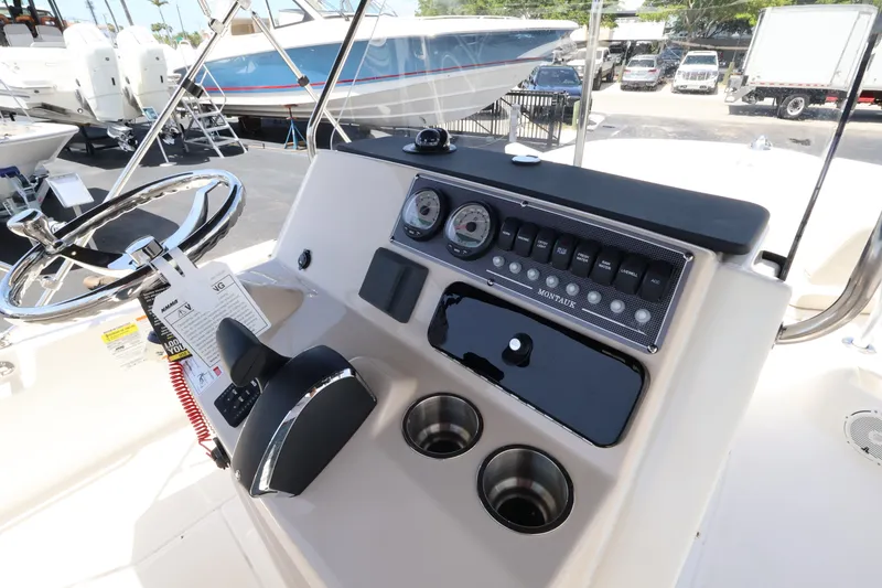 Slide: The Image of The image shows the helm of a Boston Whaler 210 Montauk with modern instruments and cup holders. - 18