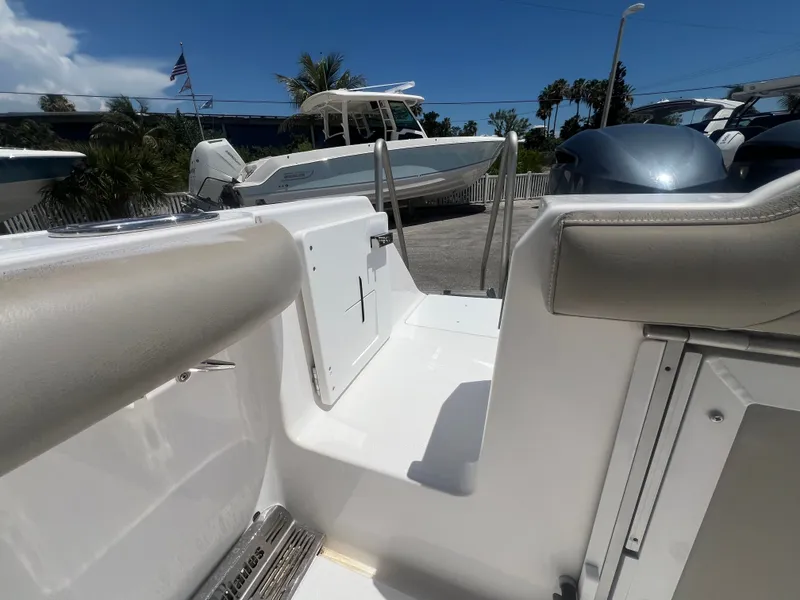 Slide: The Image of A 2019 Everglades 295 Center Console boat on a parking lot. Palm trees are visible in the background. - 10