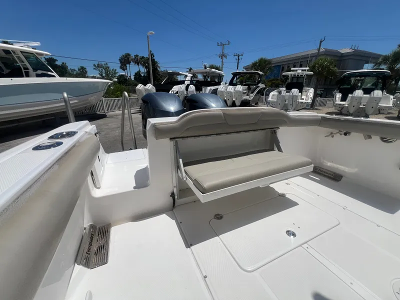 Slide: The Image of The image shows the stern of a 2019 Everglades 295 Center Console boat with a foldable bench seat and two outboard engines. - 11