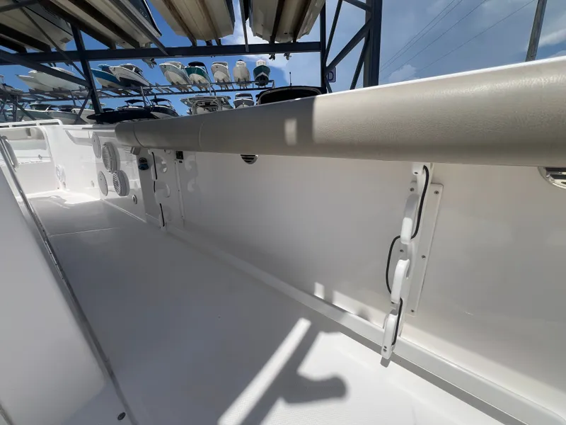Slide: The Image of The image shows the interior of a 2019 Everglades 295 Center Console boat with white walls and gray upholstery. - 41