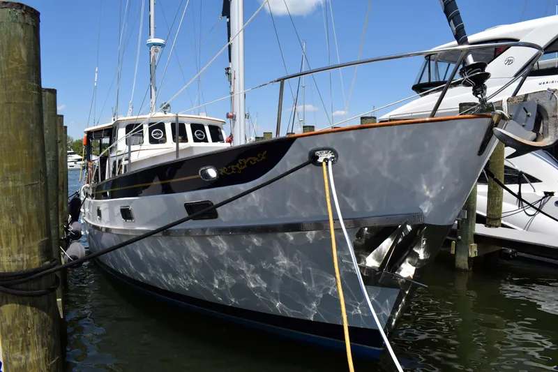 Slide: The Image of 1980 Cheoy Lee 52 Motorsailer docked at marina under clear blue sky. - 2