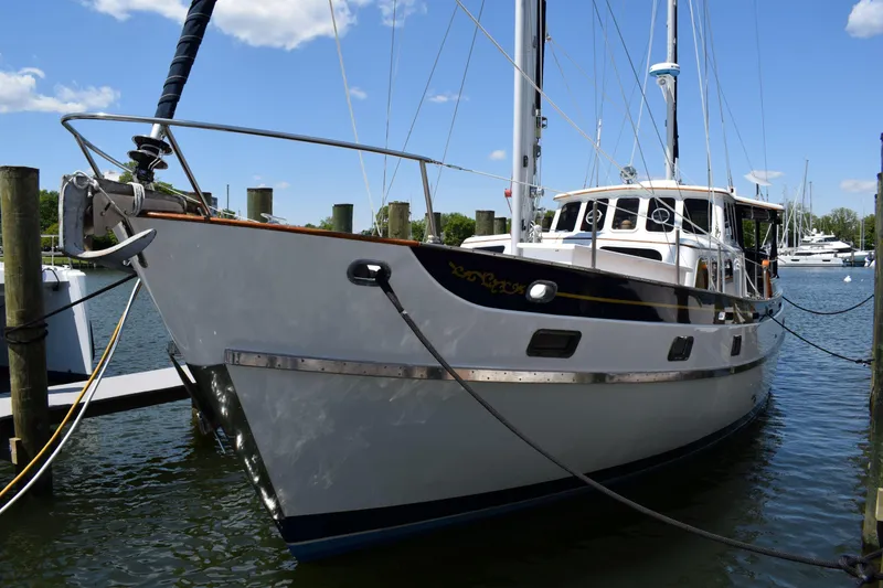 Slide: The Image of 1980 Cheoy Lee 52 Motorsailer docked at marina under clear blue sky. - 3