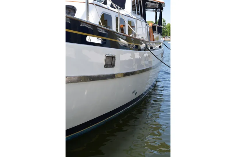 Slide: The Image of 1980 Cheoy Lee 52 Motorsailer yacht docked on calm water. - 5