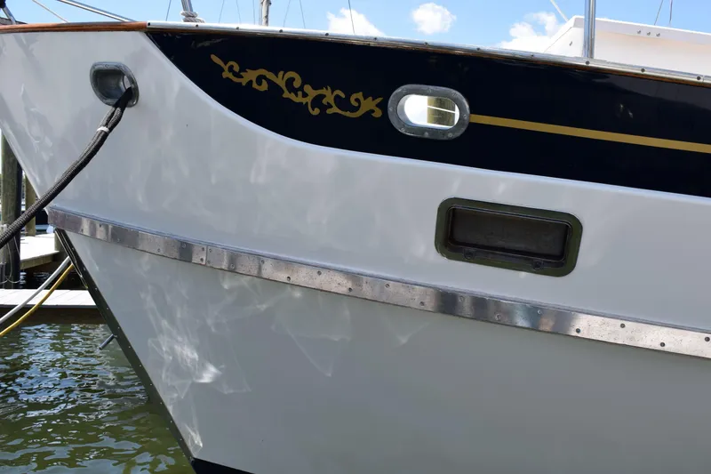 Slide: The Image of 1980 Cheoy Lee 52 Motorsailer boat hull with decorative trim and porthole. - 6