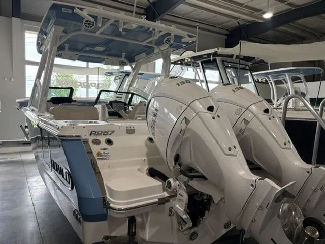 Slide: The Image of 2026 Robalo R257 Dual Console in showroom with twin outboard engines. - 2
