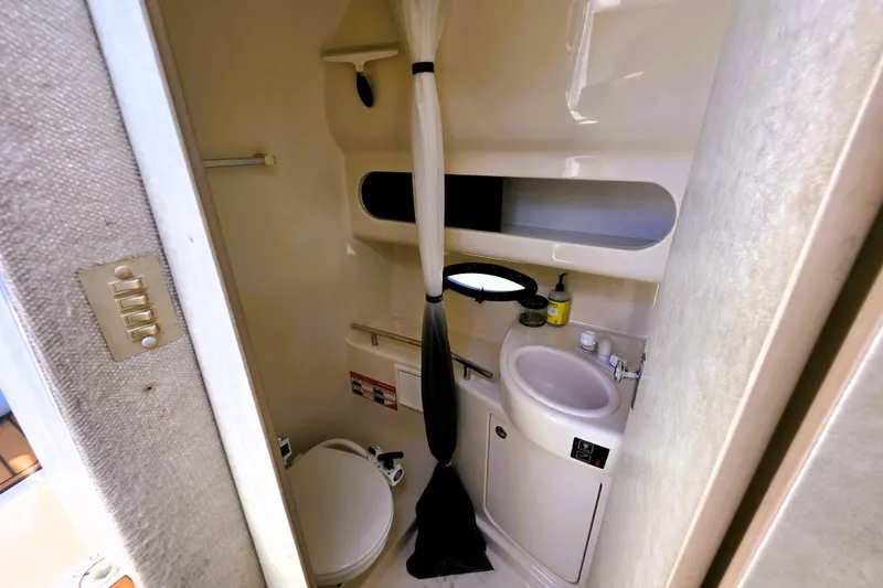 Slide: The Image of 1999 Bayliner 3055 Ciera bathroom with toilet, sink, and shower curtain. - 14