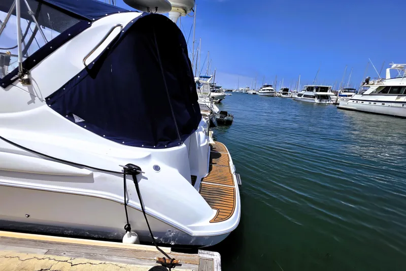 Slide: The Image of 1999 Bayliner 3055 Ciera docked at a marina, surrounded by other boats. - 3