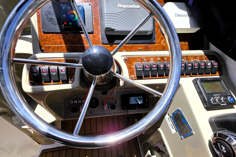 Slide: The Image of 1999 Bayliner 3055 Ciera helm with steering wheel, control panel, and navigation instruments. - 9