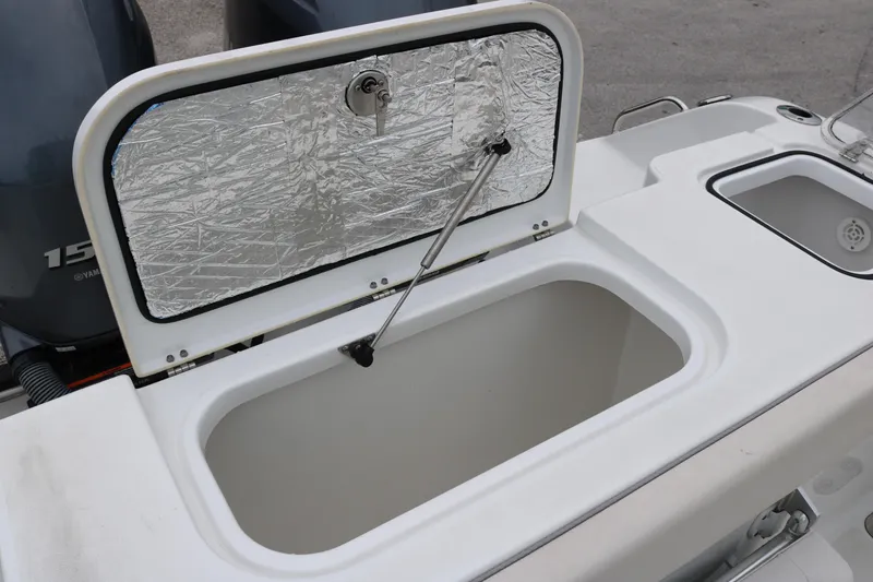 Slide: The Image of 2023 Sea Hunt Gamefish 25 boat with open storage compartment and Yamaha engines. - 17