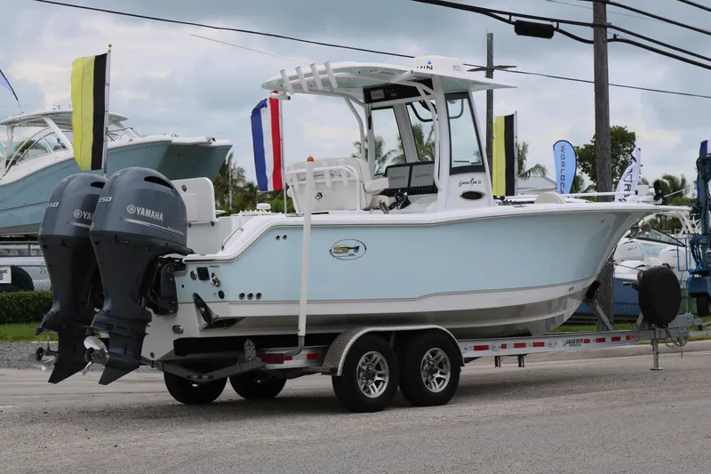 Slide: The Image of 2023 Sea Hunt Gamefish 25 boat with dual Yamaha engines on a trailer. - 2