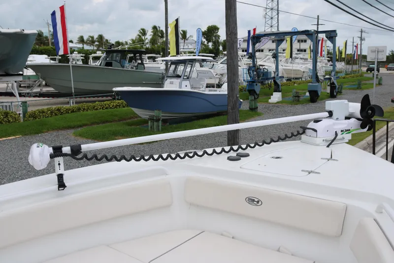Slide: The Image of 2023 Sea Hunt Gamefish 25 boat with trolling motor, displayed at a marina. - 7