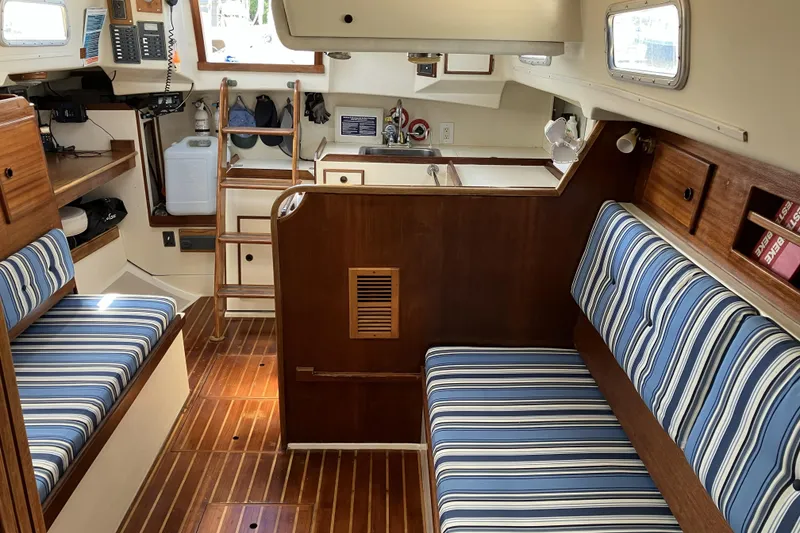 Slide: The Image of Interior of 1981 Pearson 365 Ketch sailboat with striped cushions and wooden finishes. - 12