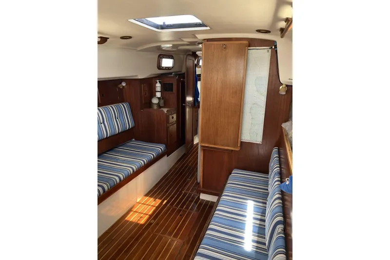 Slide: The Image of Interior of 1981 Pearson 365 Ketch sailboat with striped seating and wooden cabinetry. - 13
