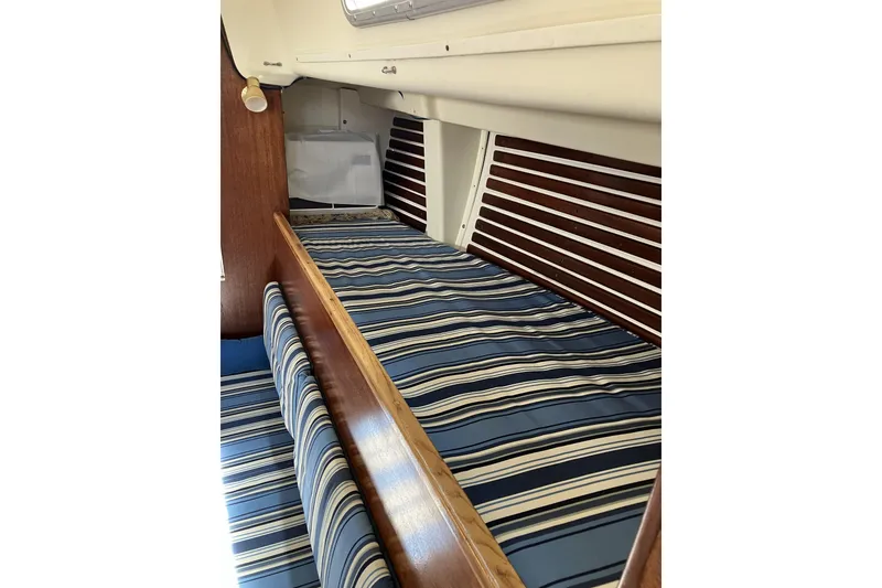 Slide: The Image of Interior of 1981 Pearson 365 Ketch sailboat with striped bedding and wooden accents. - 15