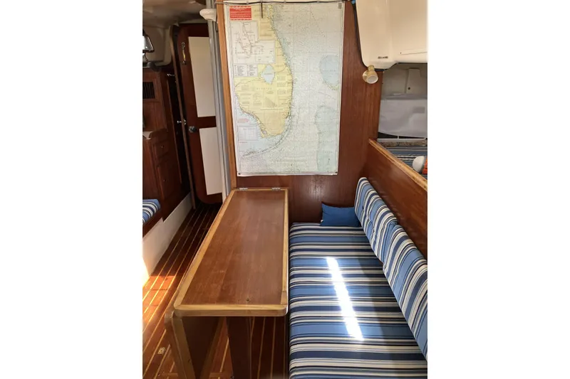 Slide: The Image of Interior of 1981 Pearson 365 Ketch sailboat with striped seating and nautical map. - 16
