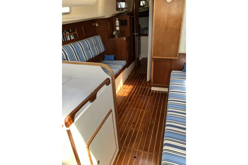 Slide: The Image of Interior of 1981 Pearson 365 Ketch sailboat with striped seating and wooden flooring. - 17
