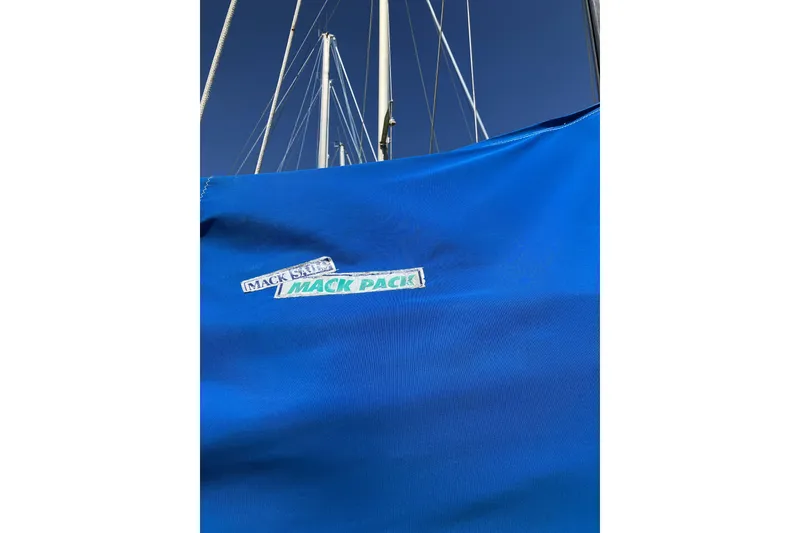 Slide: The Image of Blue sail cover on 1981 Pearson 365 Ketch with "Mack Pack" label, against clear sky. - 40