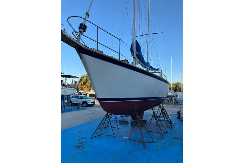 Slide: The Image of 1981 Pearson 365 Ketch sailboat on stands, blue sky background. - 44