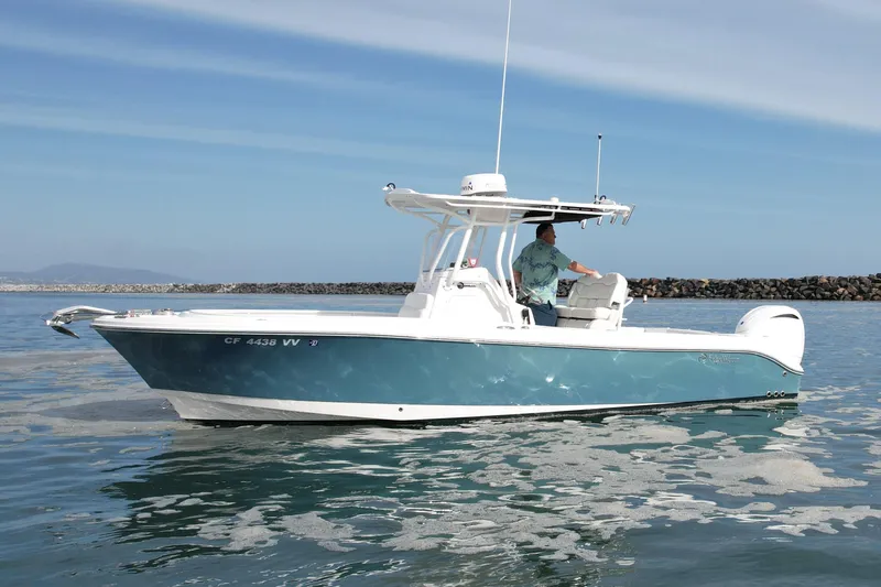 Slide: The Image of 2023 Edgewater 245CC boat cruising on calm waters under a clear blue sky. - 1