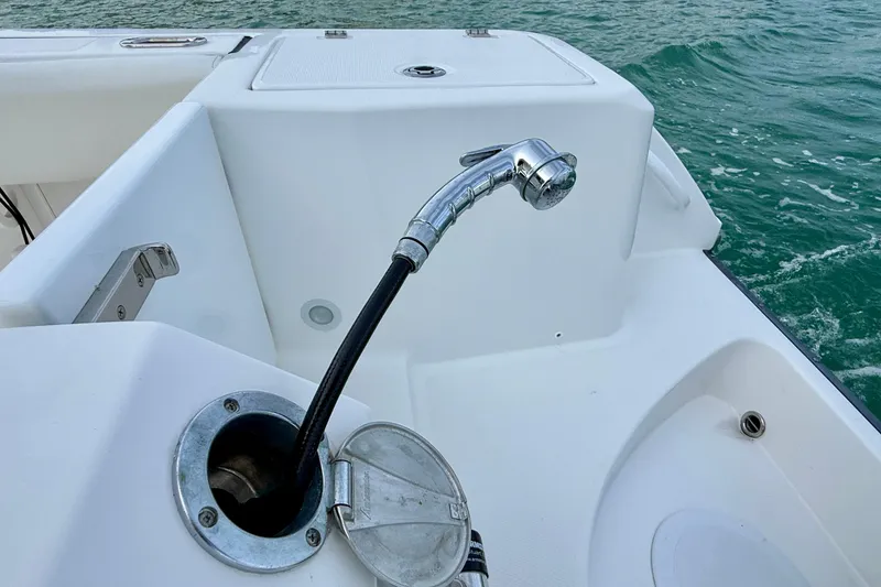 Slide: The Image of Edgewater 245CC 2023 boat deck with a chrome showerhead and ocean view. - 10