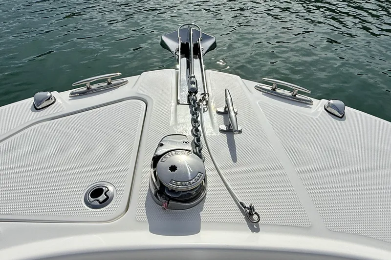 Slide: The Image of Bow of 2023 Edgewater 245CC boat with anchor and cleats on calm water. - 14