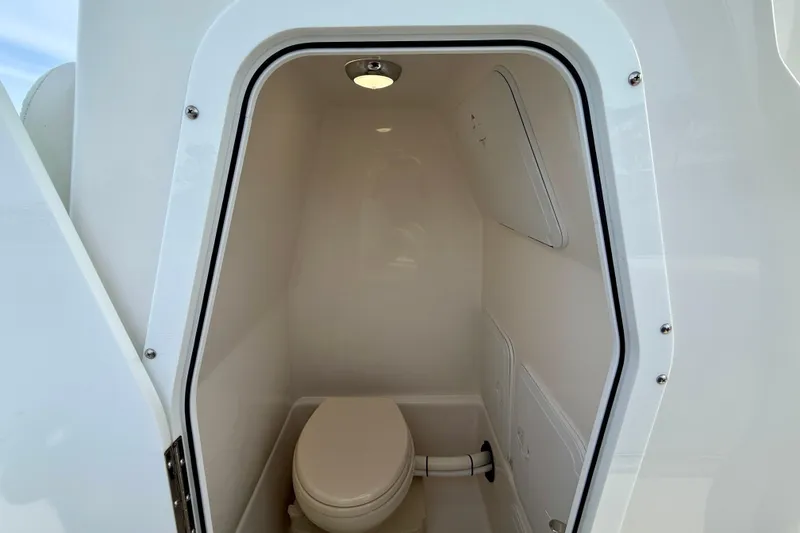 Slide: The Image of 2023 Edgewater 245CC boat interior with compact marine toilet and lighting. - 27